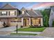 Beautiful home at dusk with manicured lawn, stone and siding details, and a welcoming front porch at 2940 W Village Dr # 60, Suwanee, GA 30024