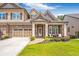 Beautiful home with stone accents, a two-car garage, and a well-maintained lawn at 2940 W Village Dr # 60, Suwanee, GA 30024
