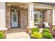 Inviting covered front porch with brick accents, stylish seating, and well-manicured landscaping at 2940 W Village Dr # 60, Suwanee, GA 30024