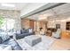 Spacious open-concept living room with a stone accent wall, hardwood floors, modern lighting, and a view of the kitchen at 2940 W Village Dr # 60, Suwanee, GA 30024