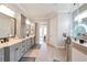 Open view of bright bathroom with double sinks, tiled floors and a glass enclosed shower at 2940 W Village Dr # 60, Suwanee, GA 30024