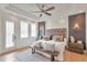 Comfortable main bedroom with wooden floors, neutral colors, and a large upholstered headboard at 2940 W Village Dr # 60, Suwanee, GA 30024