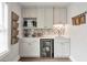 Stylish wet bar featuring custom cabinets, a beverage fridge, and decorative backsplash at 2940 W Village Dr # 60, Suwanee, GA 30024