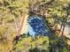 Aerial view of a community tennis court nestled among lush trees, providing a private recreational space at 3011 Canyon Point Cir, Roswell, GA 30076