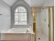 Bathroom featuring a soaking tub, shower and a window providing lots of natural light at 10460 Cranchester Way, Alpharetta, GA 30022
