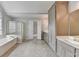 Bright bathroom featuring a soaking tub, glass-enclosed shower, and double vanity at 10460 Cranchester Way, Alpharetta, GA 30022