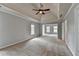 Spacious bedroom with tray ceiling, ceiling fan, neutral carpet, and large windows at 10460 Cranchester Way, Alpharetta, GA 30022