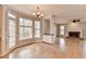 Dining area with chandelier, view into living room, and hardwood floors at 10460 Cranchester Way, Alpharetta, GA 30022
