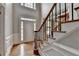 Bright entryway featuring hardwood floors, a staircase with iron spindles, and classic white trim, creating a welcoming ambiance at 10460 Cranchester Way, Alpharetta, GA 30022