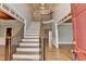 Inviting foyer featuring a staircase, hardwood floors, and neutral walls, creating a bright and welcoming entrance at 10460 Cranchester Way, Alpharetta, GA 30022