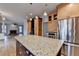Kitchen featuring granite island, stainless steel refrigerator, hardwood floors, and view into the living room at 10460 Cranchester Way, Alpharetta, GA 30022