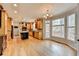 Open kitchen concept with dining area, granite island, and wood floors at 10460 Cranchester Way, Alpharetta, GA 30022