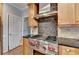 Up close shot of kitchen with stainless steel oven and hood with tile backsplash at 10460 Cranchester Way, Alpharetta, GA 30022