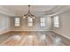 Spacious living room featuring hardwood floors, abundant light, and modern chandelier at 10460 Cranchester Way, Alpharetta, GA 30022