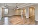 Spacious open-concept living room featuring tray ceilings, wood floors and a modern chandelier at 10460 Cranchester Way, Alpharetta, GA 30022