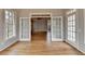 Spacious living room with beautiful hardwood floors and French doors leading to other rooms at 10460 Cranchester Way, Alpharetta, GA 30022