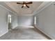 Large main bedroom with carpet, tray ceilings, ceiling fan, neutral paint, and bathroom at 10460 Cranchester Way, Alpharetta, GA 30022