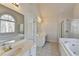 Bright bathroom featuring a double vanity, large tub, glass-door shower, and a window providing natural light at 1924 Wilkenson Xing, Marietta, GA 30066