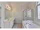 Bright bathroom featuring a large tub, glass-door shower, and a window providing natural light at 1924 Wilkenson Xing, Marietta, GA 30066