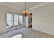 Dining area with elegant chandelier, chair rail, and large windows looking to backyard at 1924 Wilkenson Xing, Marietta, GA 30066