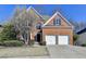 Charming two-story brick home with a well-manicured lawn, two-car garage, and a welcoming front entrance at 1924 Wilkenson Xing, Marietta, GA 30066