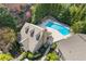 An aerial view of home showcasing a backyard swimming pool, stone patio, and lush landscaping at 3155 Seven Pines Ct # 303, Atlanta, GA 30339