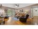 Living room featuring hardwood floors, ceiling fan, a brown sofa and access to a patio at 3155 Seven Pines Ct # 303, Atlanta, GA 30339