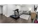 The basement area features wood floors, a gray sofa, a tv, and a treadmill at 4062 Silver Fir Ct, Marietta, GA 30066