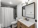 This bathroom includes a shower with tile, white toilet, and a wood grain vanity with black hardware at 4062 Silver Fir Ct, Marietta, GA 30066