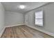 Bedroom featuring wood-look floors, neutral walls, window, and door to the exterior at 5880 April Dr, Sugar Hill, GA 30518