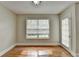 Bright bedroom with hardwood floors, large window, and door leading to outdoor space at 5880 April Dr, Sugar Hill, GA 30518
