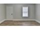 This bedroom features wood-look flooring, a window for natural light and a white door at 5880 April Dr, Sugar Hill, GA 30518