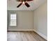 Bright bedroom featuring hardwood floors, natural light, and a contemporary ceiling fan at 5880 April Dr, Sugar Hill, GA 30518
