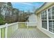 Backyard deck featuring wood-look flooring and white railings overlooking lawn and treeline at 5880 April Dr, Sugar Hill, GA 30518