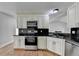 Well-equipped kitchen boasts white cabinets, granite countertops, and stainless steel appliances at 5880 April Dr, Sugar Hill, GA 30518