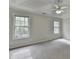 Spacious main bedroom with tray ceiling, fan, and bright windows at 5880 April Dr, Sugar Hill, GA 30518