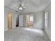 Spacious main bedroom with tray ceiling, fan, and ensuite bathroom at 5880 April Dr, Sugar Hill, GA 30518