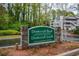 Entrance sign for Dunwoody Hills Dunwoody Lakes Private Condominium Community against a background of trees and apartments at 1602 Gettysburg Pl, Sandy Springs, GA 30350