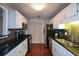 Galley-style kitchen featuring modern appliances, granite countertops, and access to a laundry room at 1602 Gettysburg Pl, Sandy Springs, GA 30350