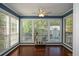 Bright sunroom boasts walls of windows, hardwood floors, and a bar cart for entertaining at 1602 Gettysburg Pl, Sandy Springs, GA 30350