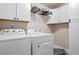 Functional laundry area with a washer, a dryer, and storage cabinets at 262 Royal Crescent Ter, Canton, GA 30115