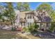 View of the back exterior featuring a brick patio and mature trees at 591 Briarmeade Sw Dr, Marietta, GA 30064