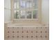 Bathroom with a tiled spa tub surrounded by bright, natural light at 591 Briarmeade Sw Dr, Marietta, GA 30064