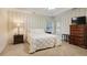 Bedroom with white wall paneling, neutral striped wallpaper, a large bed, and ample natural light at 591 Briarmeade Sw Dr, Marietta, GA 30064