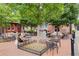 Outdoor seating area with tables and chairs, shaded by mature trees in a brick courtyard at 591 Briarmeade Sw Dr, Marietta, GA 30064