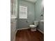 Powder room with cherry wood floors and abundant natural light at 1112 Gather Dr, Lawrenceville, GA 30043