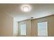 Bright bedroom with neutral walls and flooring, featuring two windows with blinds and a flush ceiling light at 1112 Gather Dr, Lawrenceville, GA 30043