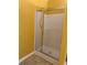 Shower with sliding glass doors, shower head, and neutral tile at 1112 Gather Dr, Lawrenceville, GA 30043