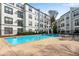 Sparkling community pool surrounded by lounge chairs, tables, and well-maintained building exterior at 400 Village Ne Pkwy # 203, Atlanta, GA 30306