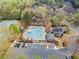Aerial view showcases community amenities with pool, tennis courts, clubhouse, ample parking, and lush landscaping at 4093 Tritt Homestead Dr, Marietta, GA 30062